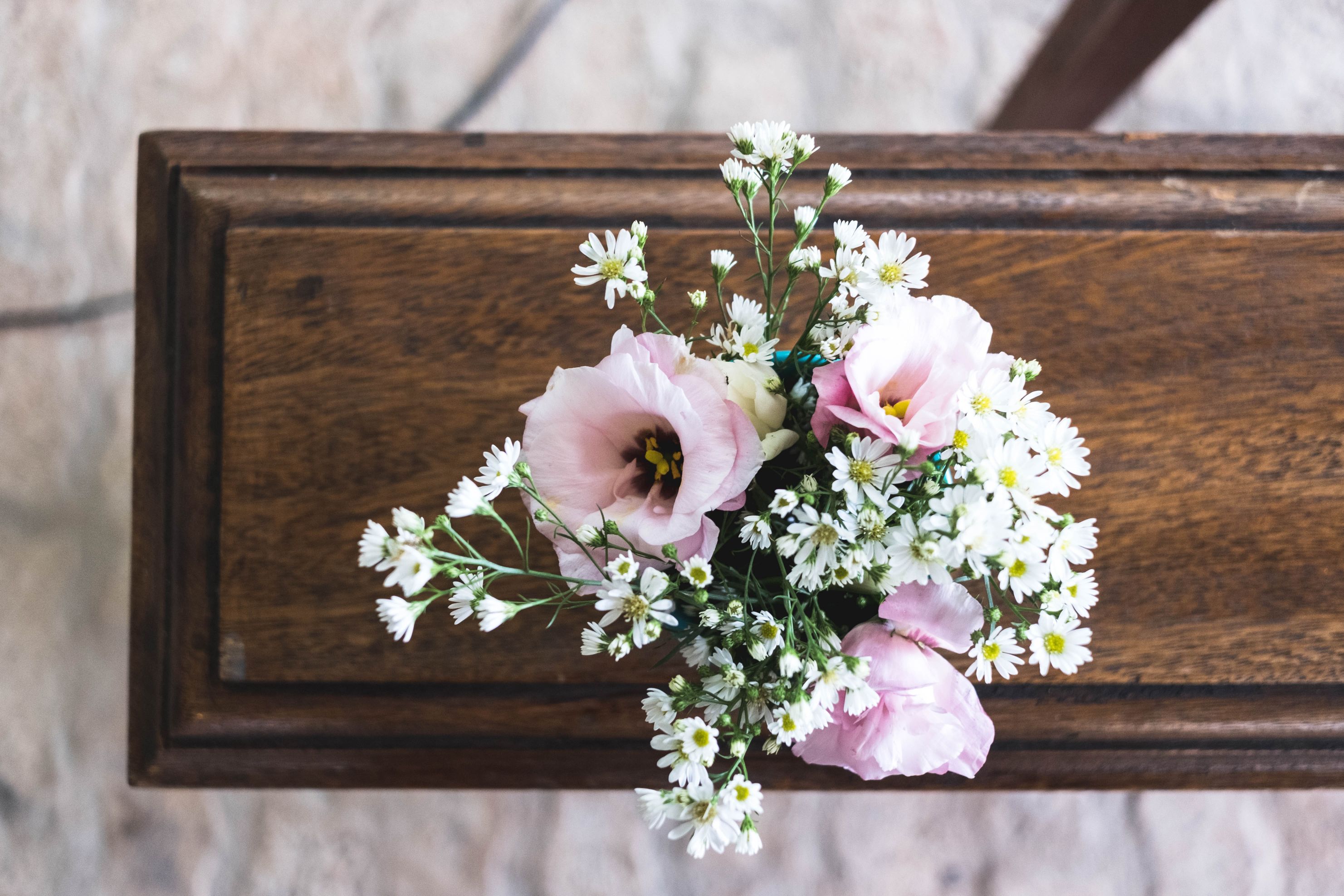 En vase med blomster i lyse farger sett ovenifra. Foto.